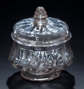 null 小型吹塑玻璃果醬罐，罐身膨脹，帶肋紋，蓋子帶蛇形把手。
18世紀
高度：11厘米