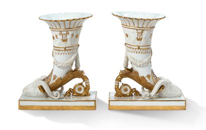 SÈVRES (GENRE DE) 
一對Rython花瓶，白釉瓷和金胎，長方形底座上有山羊頭角，浮雕飾有拿著荔枝、手鐲和水果花環的花瓶。背面的空心处有塞夫勒的隐语标记。19世纪下半叶
高24厘米，长20.5厘米...