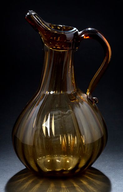 null 棕色吹制的玻璃罐，罐身为巴拉斯特形，有凹槽。镶边手柄，凸起的出水嘴
法国（诺曼底），18世纪
高26厘米；长16厘米。