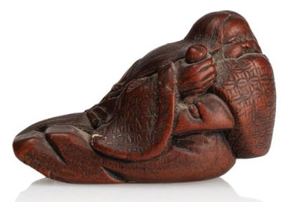 JAPON XIXE SIECLE Netsuke en bois représentant Okame allongée, riant dans sa manche....