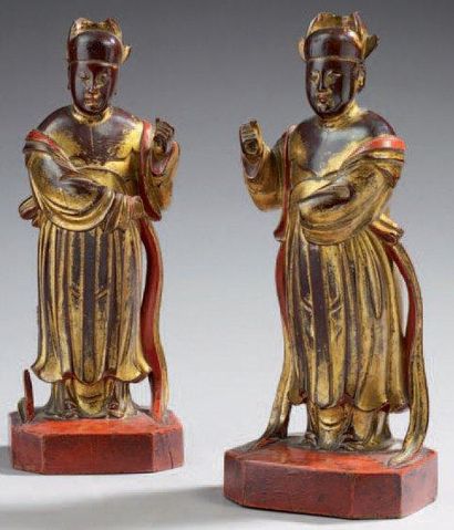 CHINE Paire de figurines représentant des serviteurs en bois laqué rouge et or ....