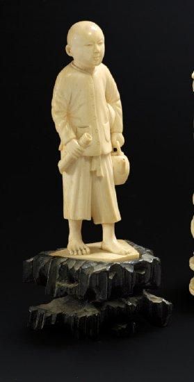 CHINE Figurine en ivoire sculptée représentant un serviteur apportant une théière...