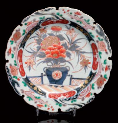 JAPON Plat rond à bordure contournée décoré dans la palette "imari" d'un vase fleuri...