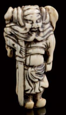 JAPON Nestuké en ivoire sculpté représentant un personnage tenant un sabre Période...