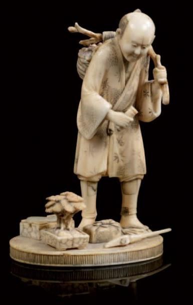 JAPON Okimono en ivoire sculpté représentant un homme dans son jardin avec à ses...