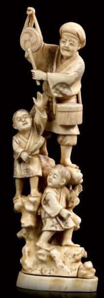 JAPON Okimono en ivoire sculpté représentant un homme et deux enfants juchés sur...