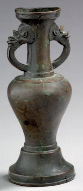 CHINE Vase d'autel en bronze à patine brune de forme balustre, les anses formées...