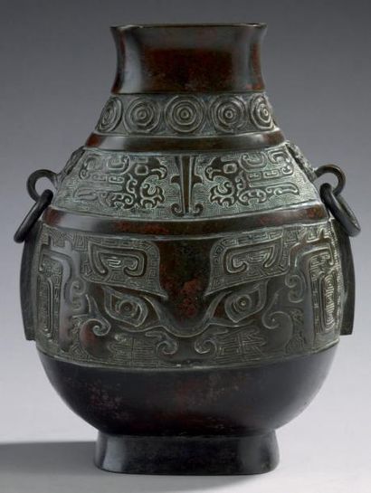 CHINE Vase en bronze à panse aplatie, à deux anses formées d'anneaux, à belle patine...