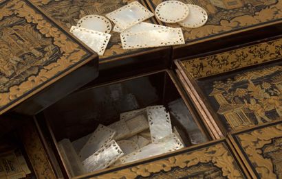 CHINE VERS 1880 


八角形的游戏盒，黑底金漆，上面有巴洛克风格的建筑景象、人物景象、花卉图案的动画奖章；包含七个盒子和四个小托盘。带有珍珠母的代币，以及用扑克牌装饰的代币架。(104代币)



尺寸：13...