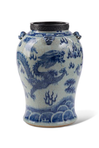 null 中国，约1900年

一个蓝白色的陶瓷花瓶，背景上有裂纹装饰，两条龙围绕着圣珠在风格化的云彩和火焰中战斗，肩上有四个浮雕的猫头。颈部被金属包围着。

...