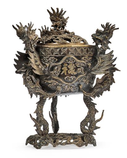 VIETNAM XXe siècle 
A tripod bronze incense burner on an openwork base. The handles...