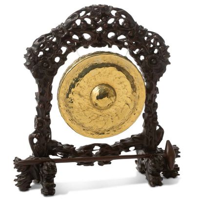 INDOCHINE XXE SIÈCLE 
A gong in copper or gilded pewter hung on its wooden base carved...