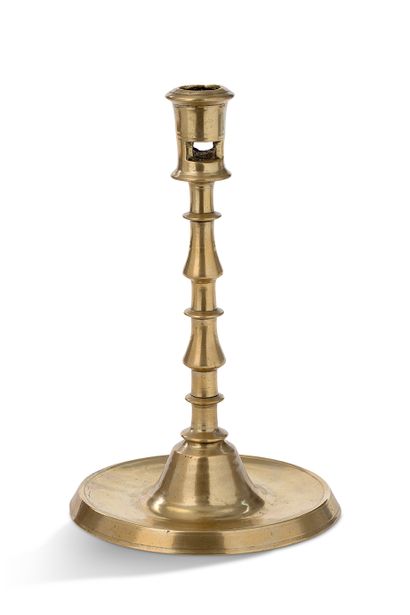 null Bronze candlestick, it rests on a flat and moulded base. Its shaft is made up...