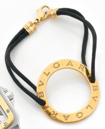 BULGARI Bracelet composé d'un anneau gravé en or jaune sur un lien noir et fermoir...