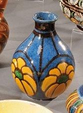 null Petit vase bouteille en terre vernissée à décor de fleurs sur fond bleu. Signé...