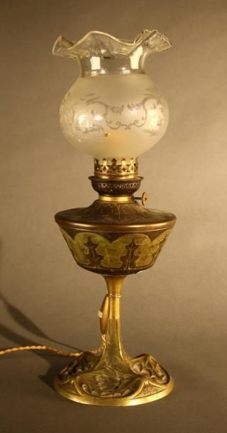GEORGES LELEU (XIX-XX) Lampe à pétrole en bronze et laiton doré à décor en relief...
