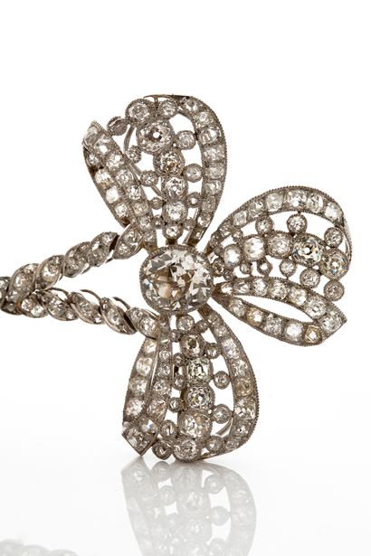 null 
BROOCH "FRONT OF BODICE 

"Bow" set with round old cut diamonds 

Platinum...