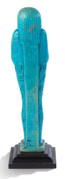 null 
巨大的PSAMTEK（或PSAMETIK）儿子SEBAREKHYT的OUSHEBTI，硅质粘土和蓝釉。一个三方条纹的头饰围绕着精心雕刻的脸部，上面有奥西里斯的胡须。他紧握的双手紧握着一把锄头，一把锄头和一根支撑背上粮袋的绳子。纤细的身体的其余部分有九行美丽的刻画象形文字（以上为转写）。普通的背柱与一个相当大的、典型的赛特式梯形底座相连，支撑着直立的木乃伊。它刻有九行象形文字的铭文，宣读了《死者之书》第三版的第六章。埃及，萨卡拉，第26王朝。公元前6世纪



高度：18.2厘米（保存非常好）



抄写：
...