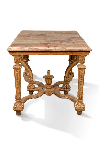 null A carved and gilded wood table, it rests on four uprights in sheath with lions'...