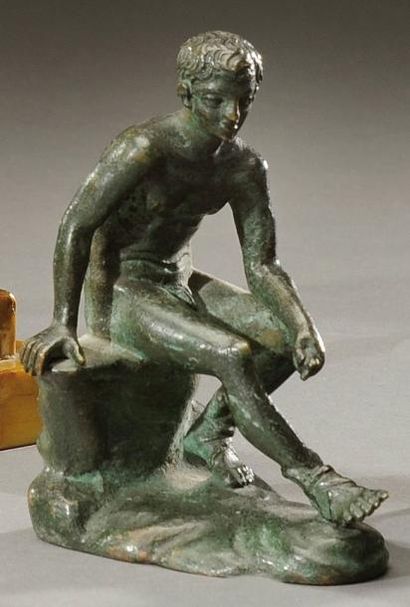 null Sujet en bronze à patine verte représentant un jeune garçon nu assis dans le...