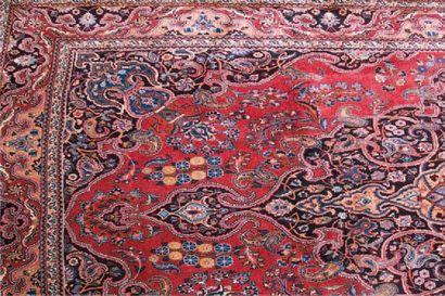 null Grand tapis MESHED (Iran) à décor de médaillon central en réserve sur fond rouge....
