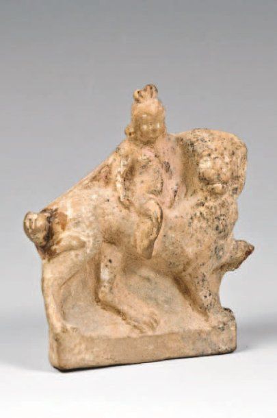 null Petite figurine représentant un éros nu juché sur un lion passant à droite....