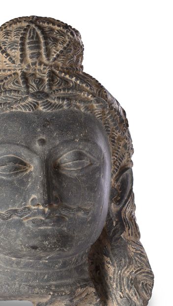 null 灰色片岩雕刻和抛光的大型BODHISATTVA头像，细小的胡须，丰富的狮子形耳环装饰（其中一个破损）。
其特有的头饰包括一个覆盖着珍珠和宝石网的发髻。解脱中的乌纳。
希腊佛教犍陀罗艺术，贵霜时期，3-4世纪...