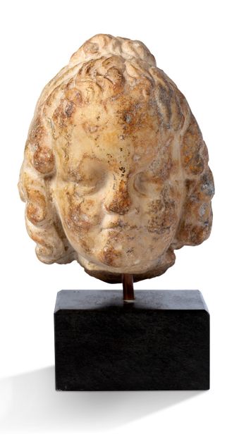 厄洛斯的白色大理石头像。这张年轻、胖乎乎的脸显示出神的特有发型：长长的波浪形头发被一条薄薄的头带环绕着，并在头顶上打了一个结。
罗马艺术，公元前1世纪
公元1世纪
高度：18.5厘米
...