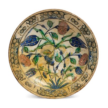 null [IZNIK]
一个硅质陶瓷 "tabak "盘子，用多色彩料装饰着花束，郁金香和康乃馨。边界上有风格化的云彩。
伊兹尼克，17世纪。
直径 : 31,3...