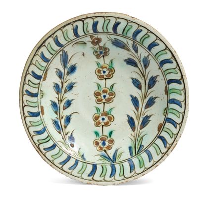 null [IZNIK]
一个硅质陶瓷 "tabak "盘，用多色装饰，上面有壁花，边上有两个金银花的花茎。绿色和蓝色鳞片的多色边界。
伊兹尼克，17世纪初。
...