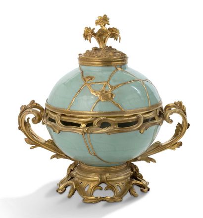 null 青花瓷壶（由金杉修复），配以路易十五时期的鎏金铜框。18世纪，约1750年。
高度：30厘米 - 宽度：30厘米
青瓷壶是18世纪中叶流行的物品之一，服装店的商人是主要的供应者。
这张照片有一个很不寻常的特点：青瓷一定是破损了，被人用黄金修复了。事实上，青瓷是一种中国瓷器，在18世纪非常珍贵，它被打破的事实并不意味着扔掉这些碎片，而是成为制作一个相当特殊的物品的借口，因为随后的修复被称为金丝楠木，它包括用覆盖着黄金的浆料将碎片...