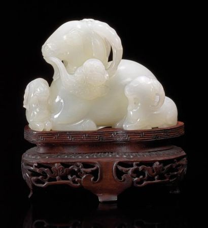 CHINE Groupe en jade clair sculpté représentant une chimère couchée tenant un champignon...