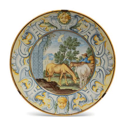CASTELLI 陶器盘，有建筑景观中的马和骑手的多色装饰。翅膀上有马斯喀彻斯和镂空的皮革。背面有蓝色签名 "Gentili.P."18世纪。
直径：24厘米（...