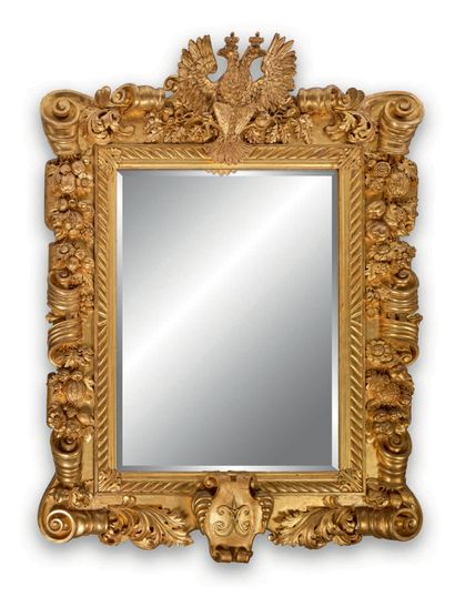 null MONUMENTAL MIRROR in richly carved and gilded wood, the pediment with a double-headed...