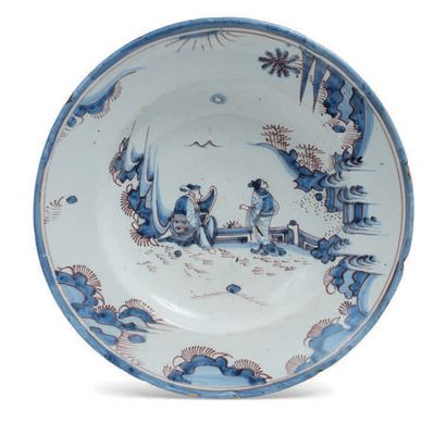 NEVERS 空心圆陶盘，以全蓝和锰的单色装饰了一对中国夫妇的风景。17世纪晚期。
直径：35,4厘米（碎片）