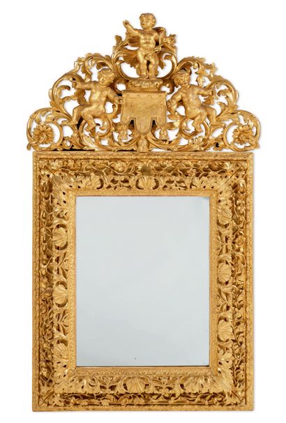 null MIRROR WITH GONFALON made of finely and richly carved and gilded wood. The rectangular...