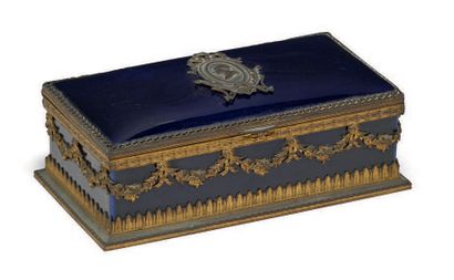 null 午夜蓝瓷器和铜制安装的长方形盒子。盒盖上有一个路易十六国王的徽章轮廓。20世纪初。
高度：6厘米 - 宽度：19厘米 深度：10厘米 (总体状况良好)