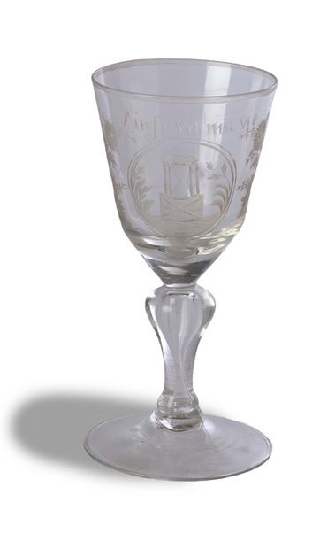 null 一个带腿的 "VANITY "玻璃杯，截顶的圆锥形碗上刻着一个沙漏轮，圆弧形的方框里有花环，上面写着 "Ainsi va ma vie"。腿部起泡，圆形脚。法国，18世纪末。
总高度：14.6厘米...