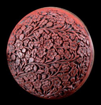 CHINE Boîte cylindrique couverte en laque rouge à motifs de fleurs sur fond de métal....