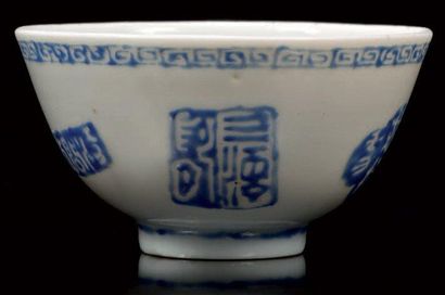 CHINE Petit bol circulaire décoré en bleu sur-couverte d'idéogrammes et de cachets....