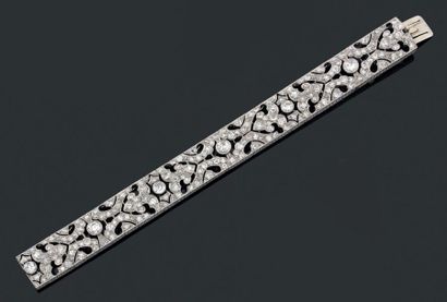 null Bracelet "ruban" articulé en platine et or gris, décor repercé serti de diamants...