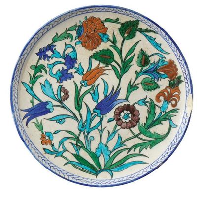 THEODOR DECK (1823-1891) Plat circulaire en faïence émaillée à décor de motifs floraux....
