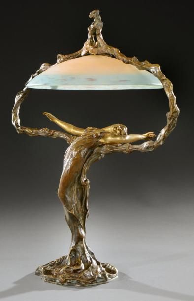 M. MELIODON (né en 1867) Lampe de bureau en bronze à patine dorée figurant une métamorphose...