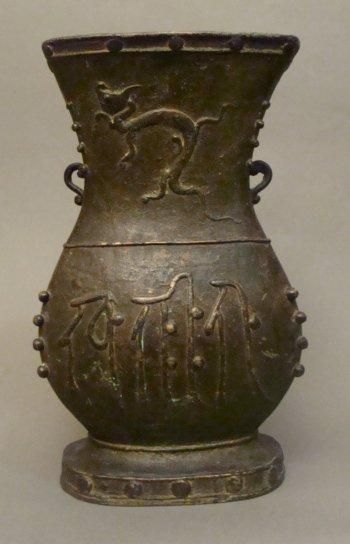CHINE Vase en bronze orné de perles et décoré sur la panse d'un dragons et de caractères....