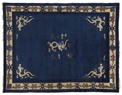 CHINE Important tapis rectangulaire en laine, le centre à fond bleu décoré de cinq...
