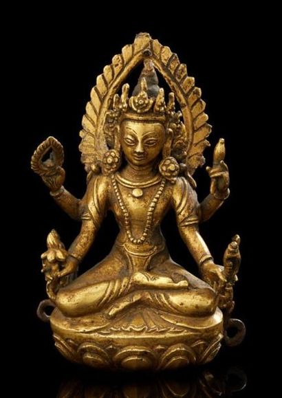 NEPAL Figurine en bronze doré représentant une divinité bouddhiste sur fond de mandorle...