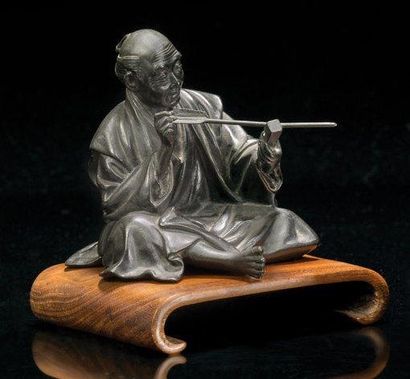 JAPON Bronze à patine brune figurant un artisan fabriquant une flèche. Signature...
