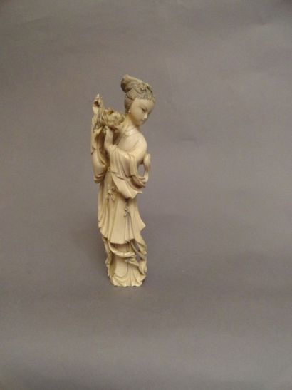 JAPON Figurine en ivoire sculpté représentant une jeune femme en kimono tenant une...
