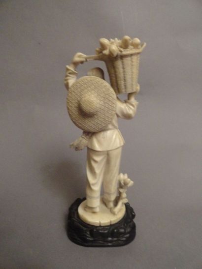 CHINE Ivoire sculpté représentant une paysanne tenant un panier rempli de pêches...