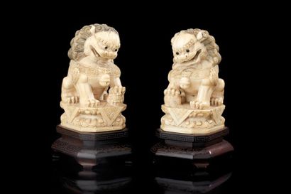 CHINE Paire de chiens de fô en ivoire sculpté assis sur des socles à double rangée...